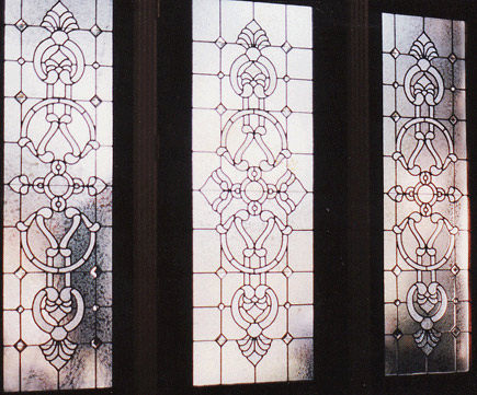 Custom entry with intricate designs in door and sidelight windows